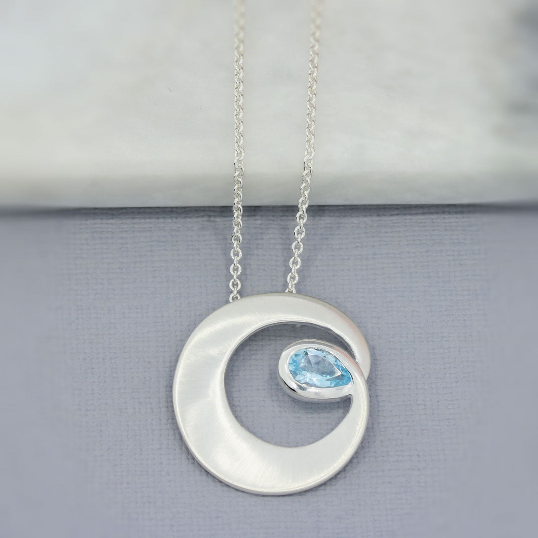 Silver Matt finish Circle Swirl Pendant with Pear Shaped Blue Topaz
