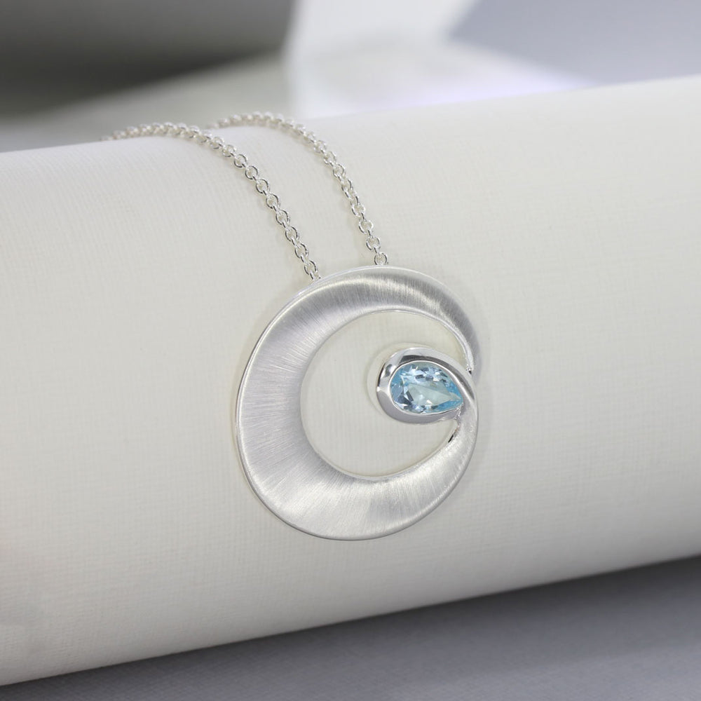 Silver Matt finish Circle Swirl Pendant with Pear Shaped Blue Topaz