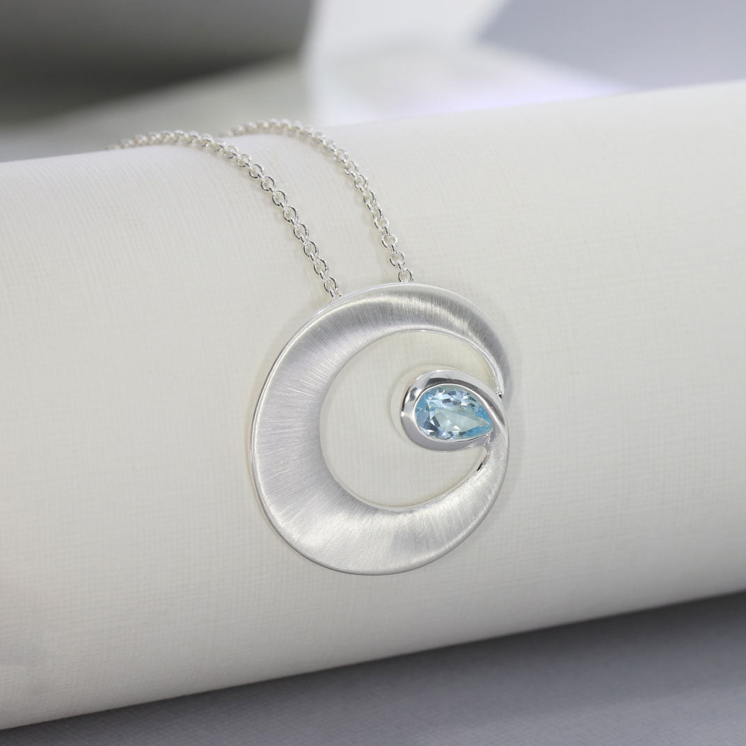 Silver Matt finish Circle Swirl Pendant with Pear Shaped Blue Topaz