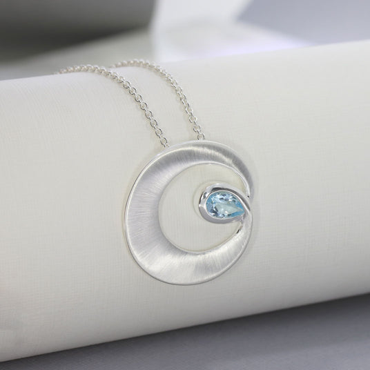 Silver Matt finish Circle Swirl Pendant with Pear Shaped Blue Topaz
