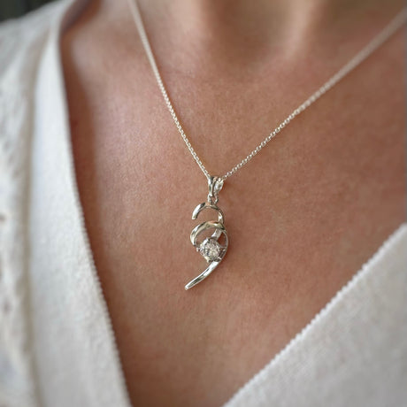 Silver ribbon swirl pendant with single round Cubic Zirconia