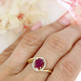 Pre Owned 14ct Gold Oval Ruby Twist Ring with Diamond Halo