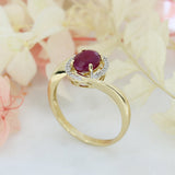 Pre Owned 14ct Gold Oval Ruby Twist Ring with Diamond Halo