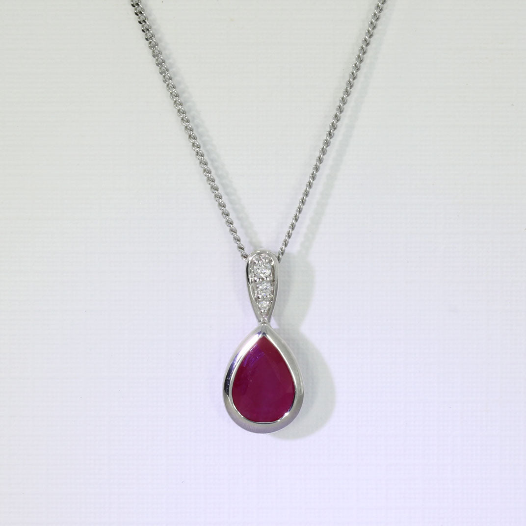 9ct White Pear Shape Ruby Pendant With Diamond Set Bale & Chain