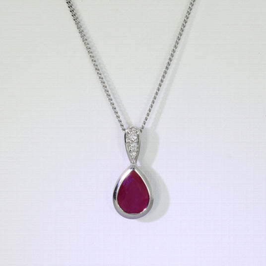 9ct White Pear Shape Ruby Pendant With Diamond Set Bale & Chain